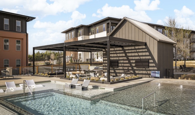 a courtyard with chairs, umbrellas, and a grilling area